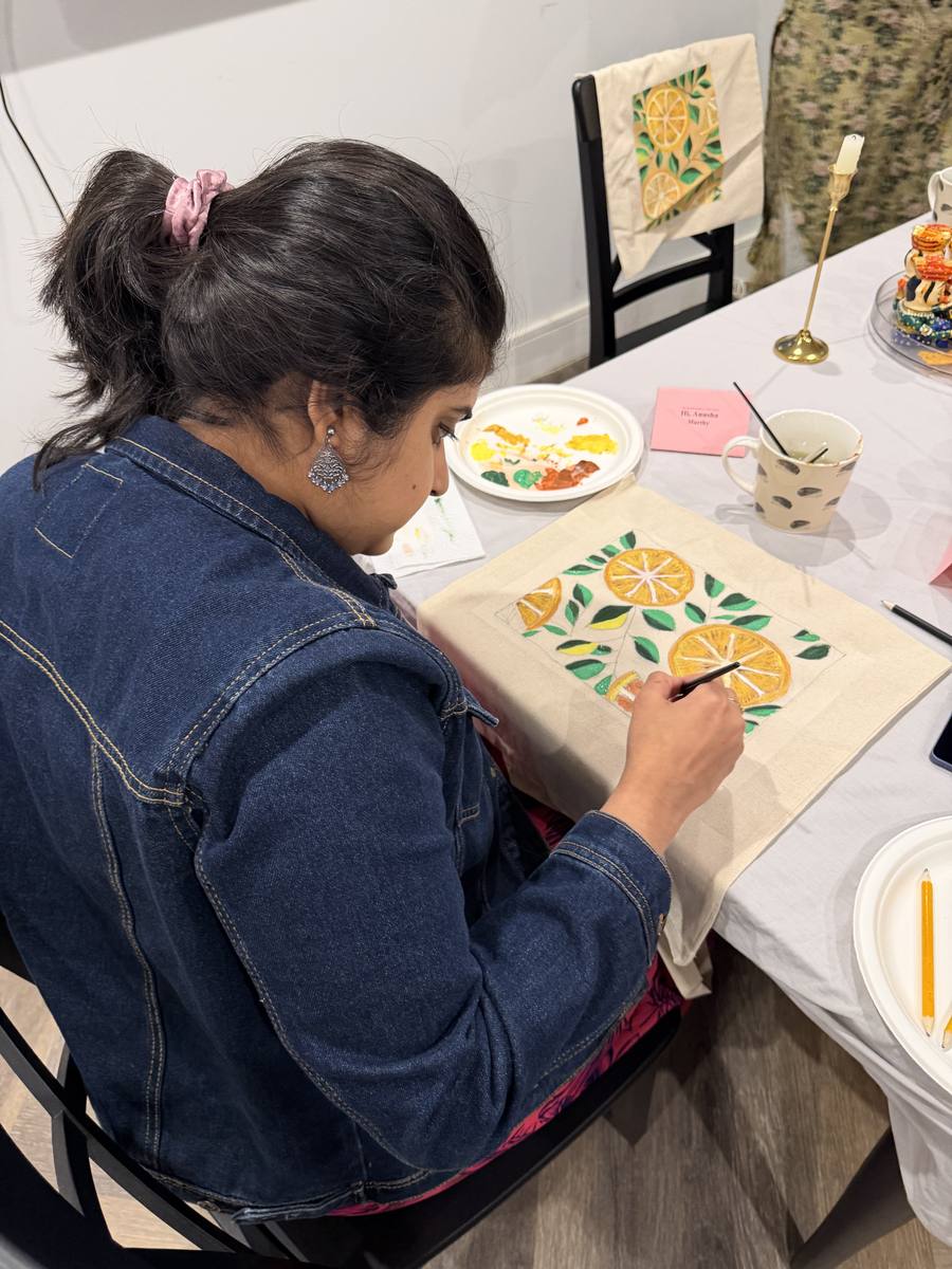 Guest adding final brushstrokes to her tote bag before supper