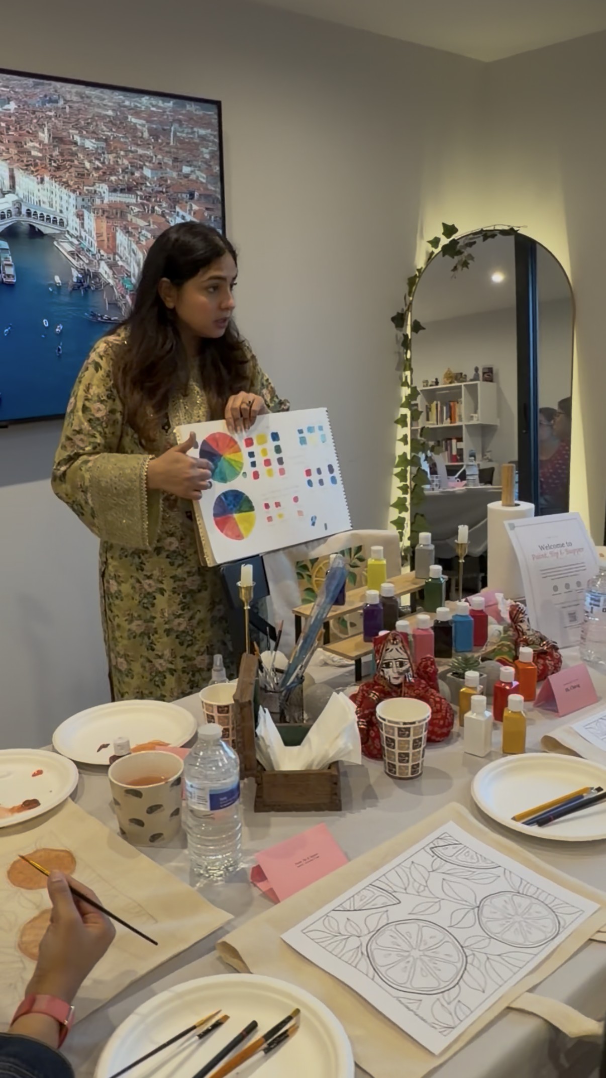 The host explaining the colour wheel to guests before painting begins