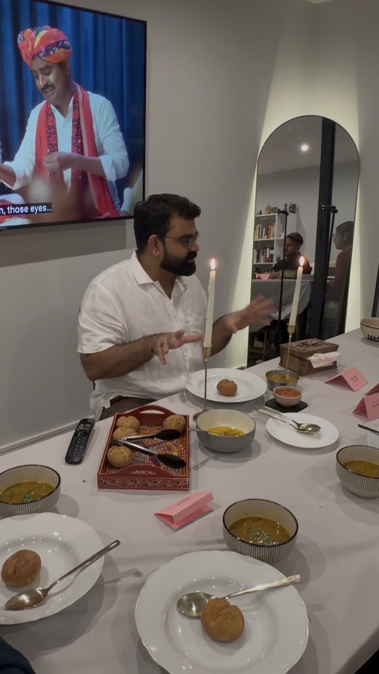 Host sharing the story behind Rajasthani cuisine as dal baati is served at the supper table
